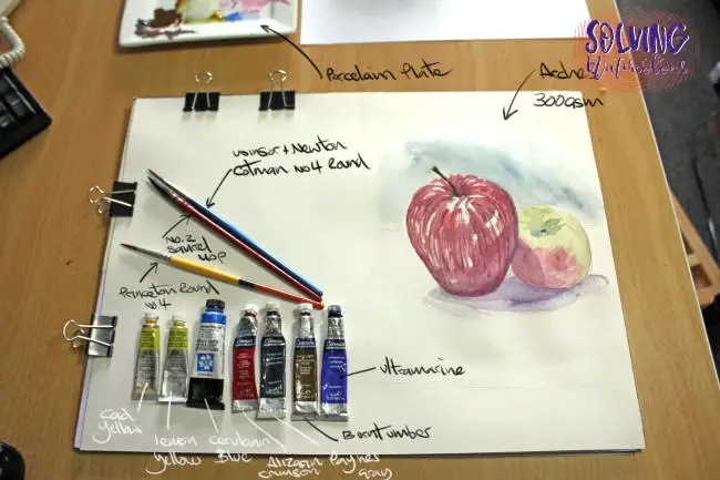 Materials used for the apples painting. Including Daniel Smith watercolor paint, Arches paper and round natural and synthetic bushes